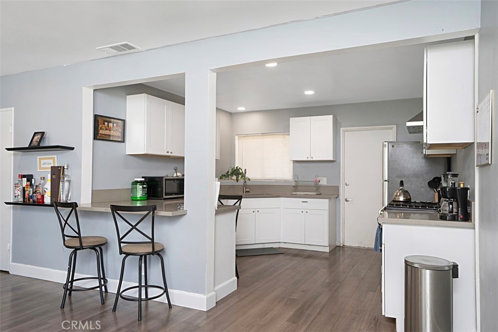 3076 Ronald Street Riverside, CA 92506 - Photo 11 of 26 a kitchen with a sink cabinets and wooden floor