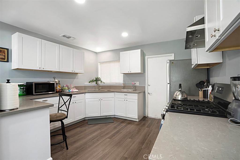3076 Ronald Street Riverside, CA 92506 - Photo 12 of 26 a kitchen with granite countertop a stove top oven a sink a counter space and cabinets