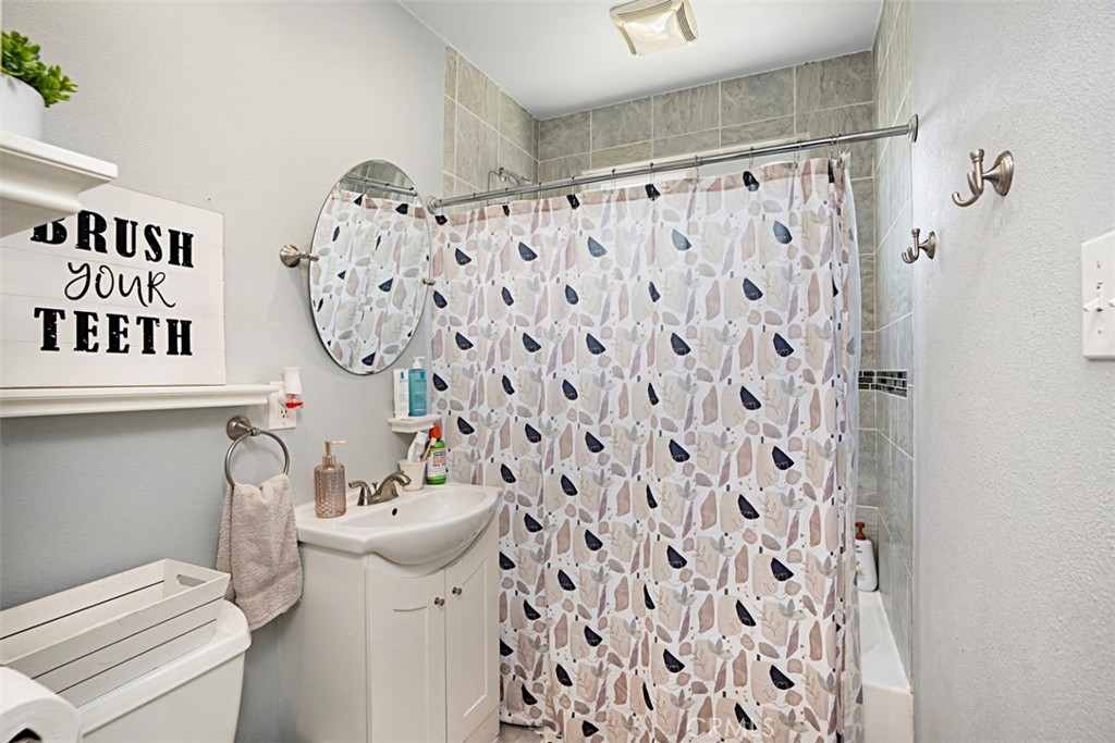 3076 Ronald Street Riverside, CA 92506 - Photo 18 of 26 a bathroom with a sink toilet and shower curtain