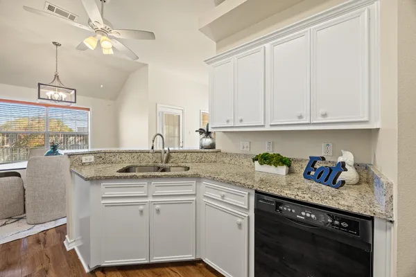 a kitchen with stainless steel appliances granite countertop a sink a stove and cabinets