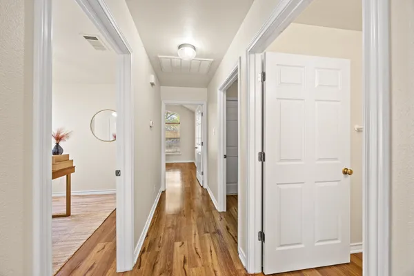 a view of a hallway with wooden floor and glass door