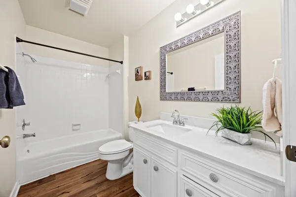 a bathroom with a sink a toilet and a large mirror