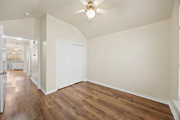 a view of a room with wooden floor and a ceiling fan