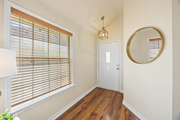 a view of a room with wooden floor and a window