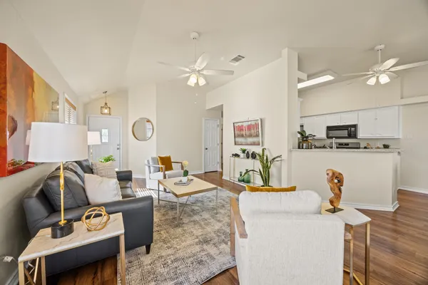 a living room with furniture a flat screen tv and kitchen view