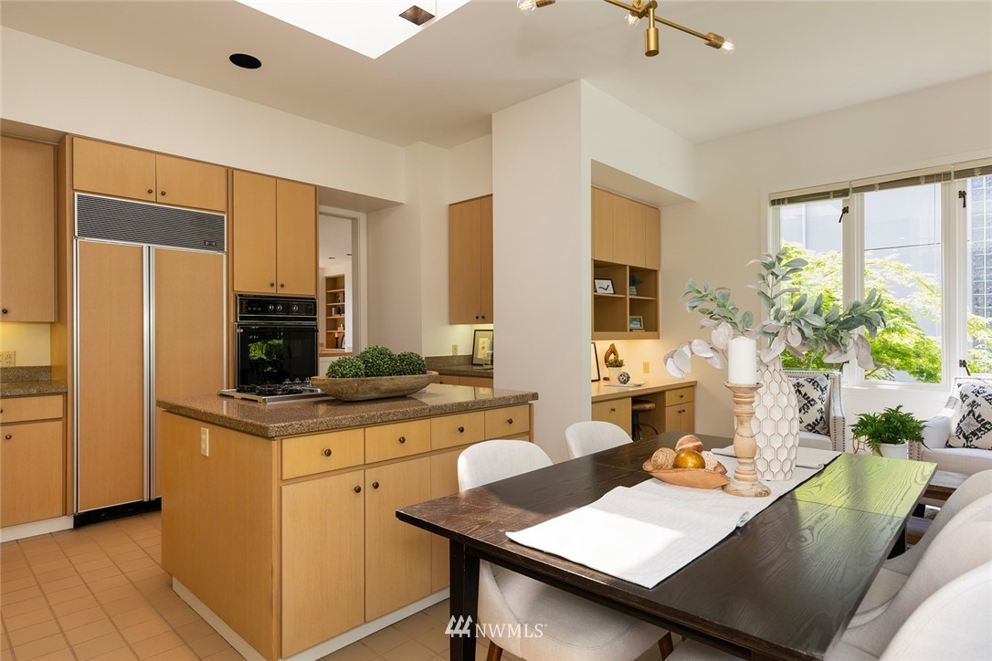 104 Highland Drive Seattle, WA 98109 - Photo 16 of 39 a view of a kitchen with kitchen island a stove a refrigerator a sink dining table and chairs