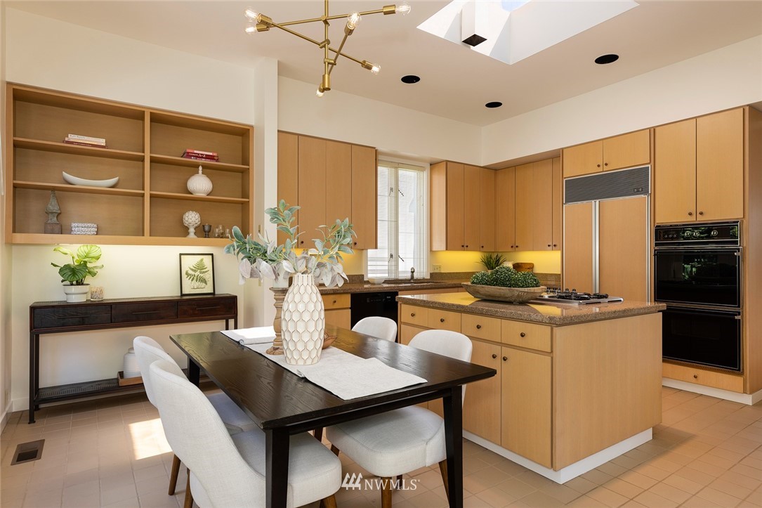 104 Highland Drive Seattle, WA 98109 - Photo 19 of 39 a kitchen with stainless steel appliances granite countertop a table chairs and a refrigerator