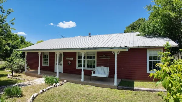 a view of a house with a yard and furniture