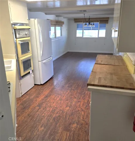 a view of a kitchen with wooden floor and electronic appliances