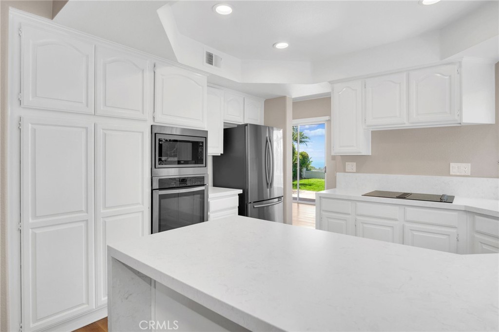 33 Dauphin Dana Point, CA 92629 - Photo 7 of 26 a kitchen with white cabinets and stainless steel appliances