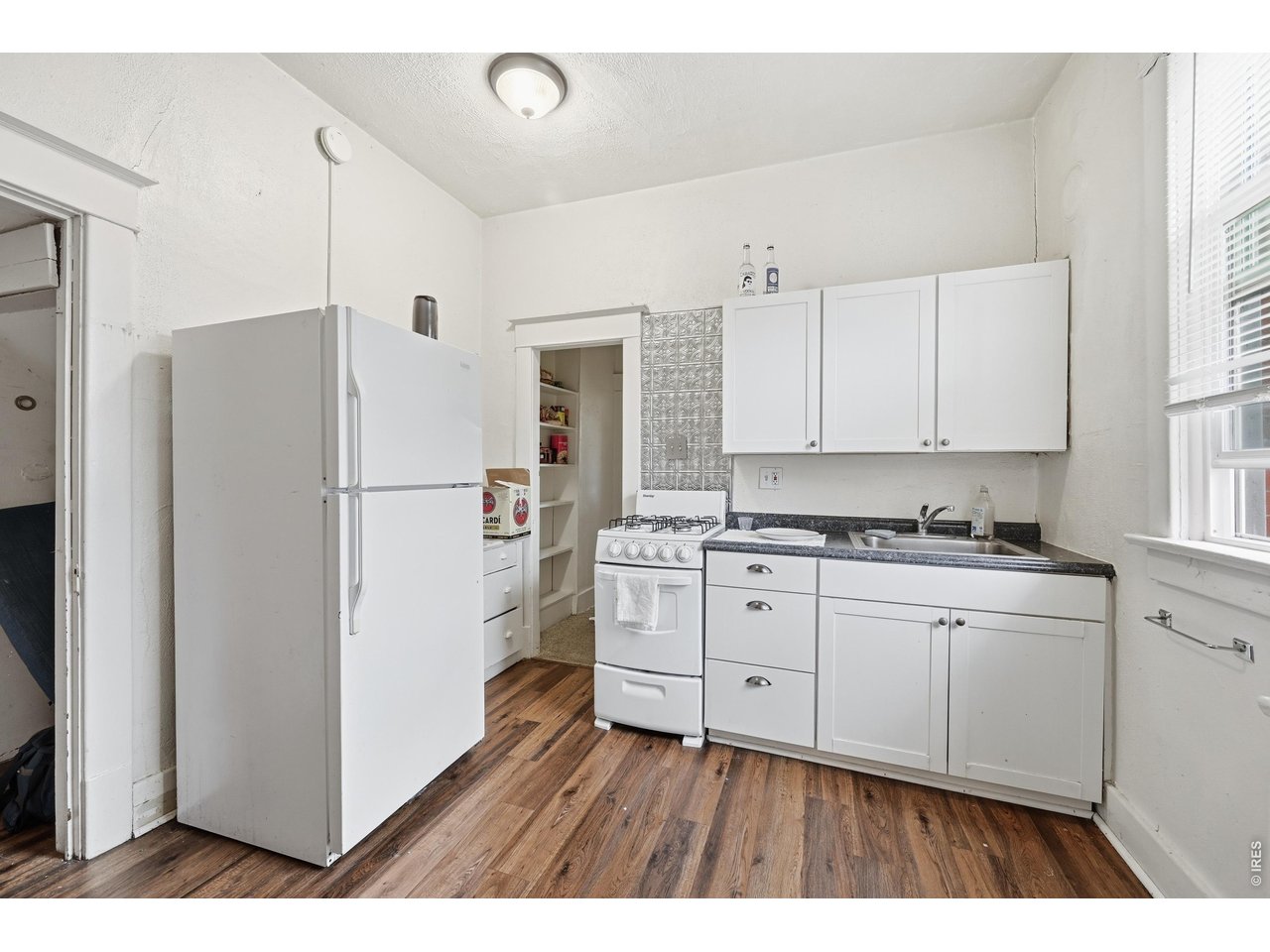 856 10th Street Boulder, CO 80302 - Photo 6 of 28 a kitchen with a refrigerator a sink and cabinets