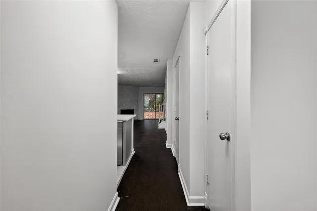 a view of a hallway with a livingroom with furniture and stairs
