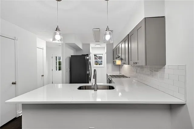 a view of a kitchen with a sink and refrigerator