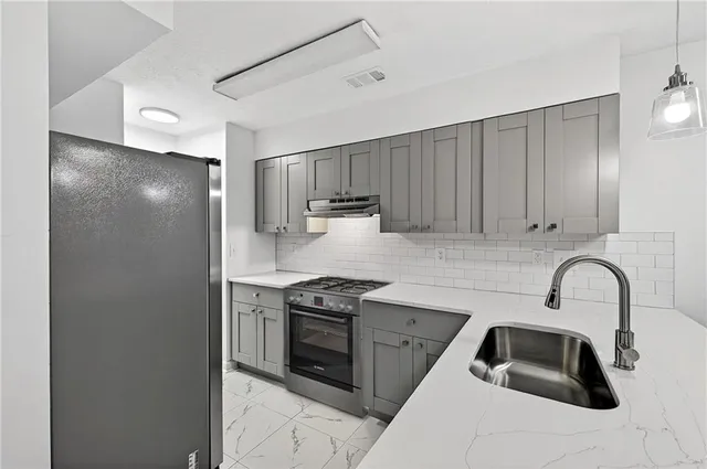 a kitchen with stainless steel appliances a sink stove and cabinets