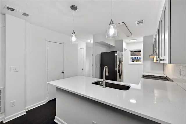 a kitchen with kitchen island a sink stainless steel appliances and window