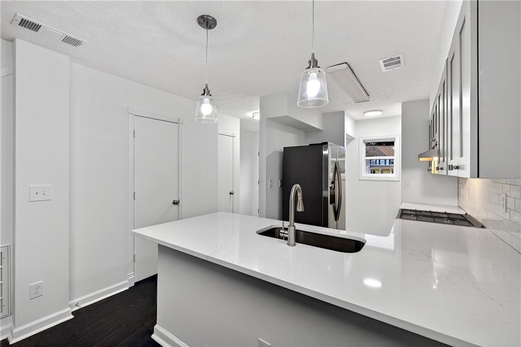 6716 Colchester Place Northwest Norcross, GA 30093 - Photo 7 of 23 a kitchen with kitchen island a sink stainless steel appliances and window