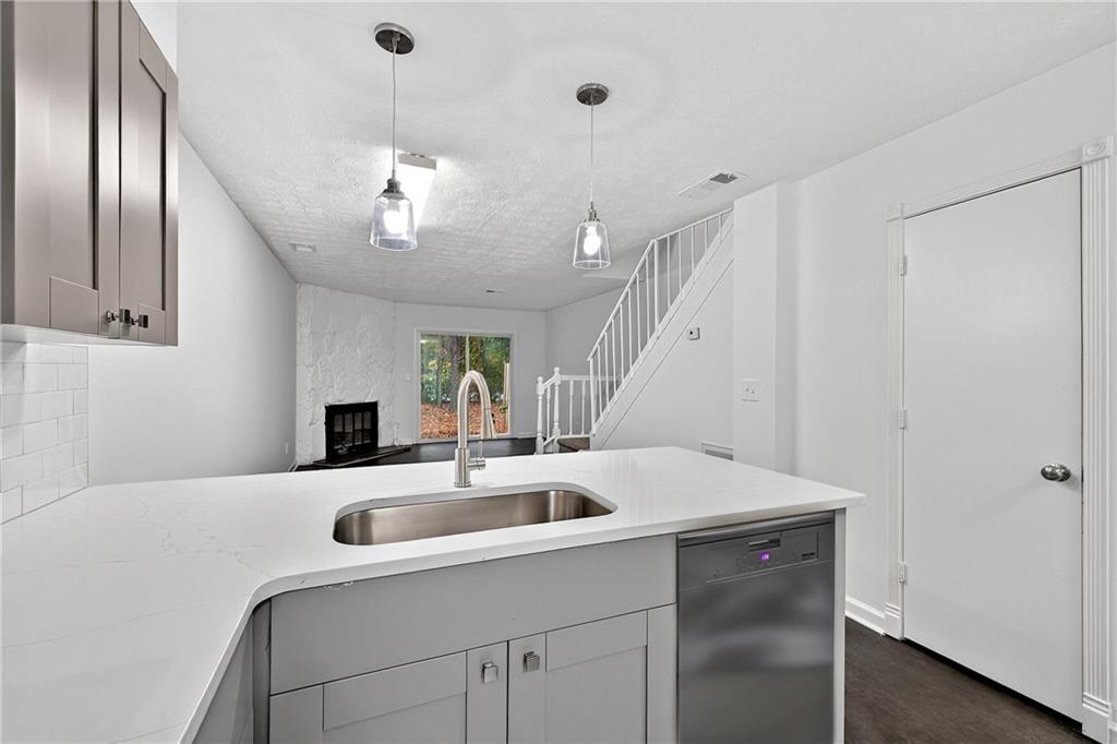 6716 Colchester Place Northwest Norcross, GA 30093 - Photo 9 of 23 a kitchen with a sink a chandelier and living room