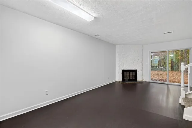 an empty room with wooden floor and fireplace