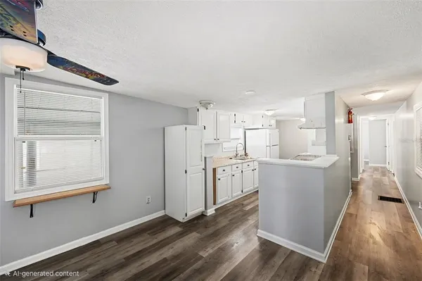 a view of a kitchen with refrigerator and wooden floor