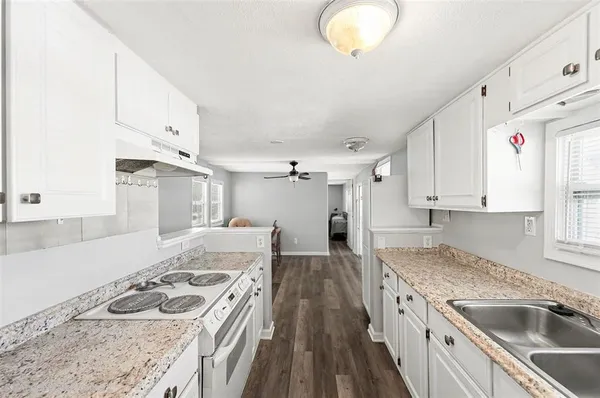 a kitchen with a stove sink and cabinets