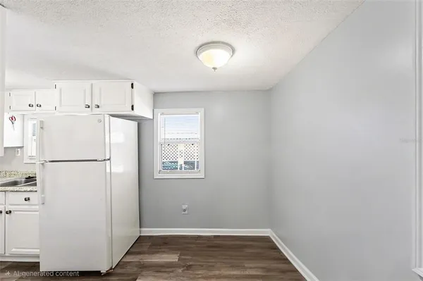 a view of a kitchen with refrigerator and white cabinets