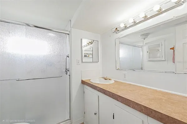 a bathroom with a granite countertop sink mirror and a shower