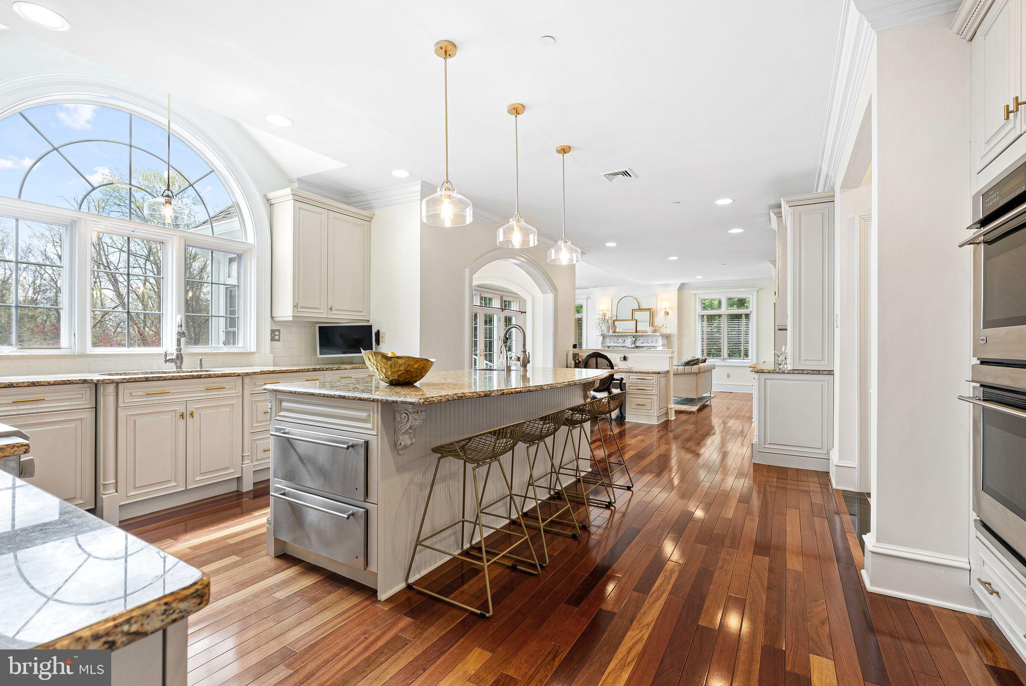 2 Greystone Circle Newtown Square, PA 19073 - Photo 8 of 57 a large kitchen with kitchen island a large island a stove a sink and a chandelier