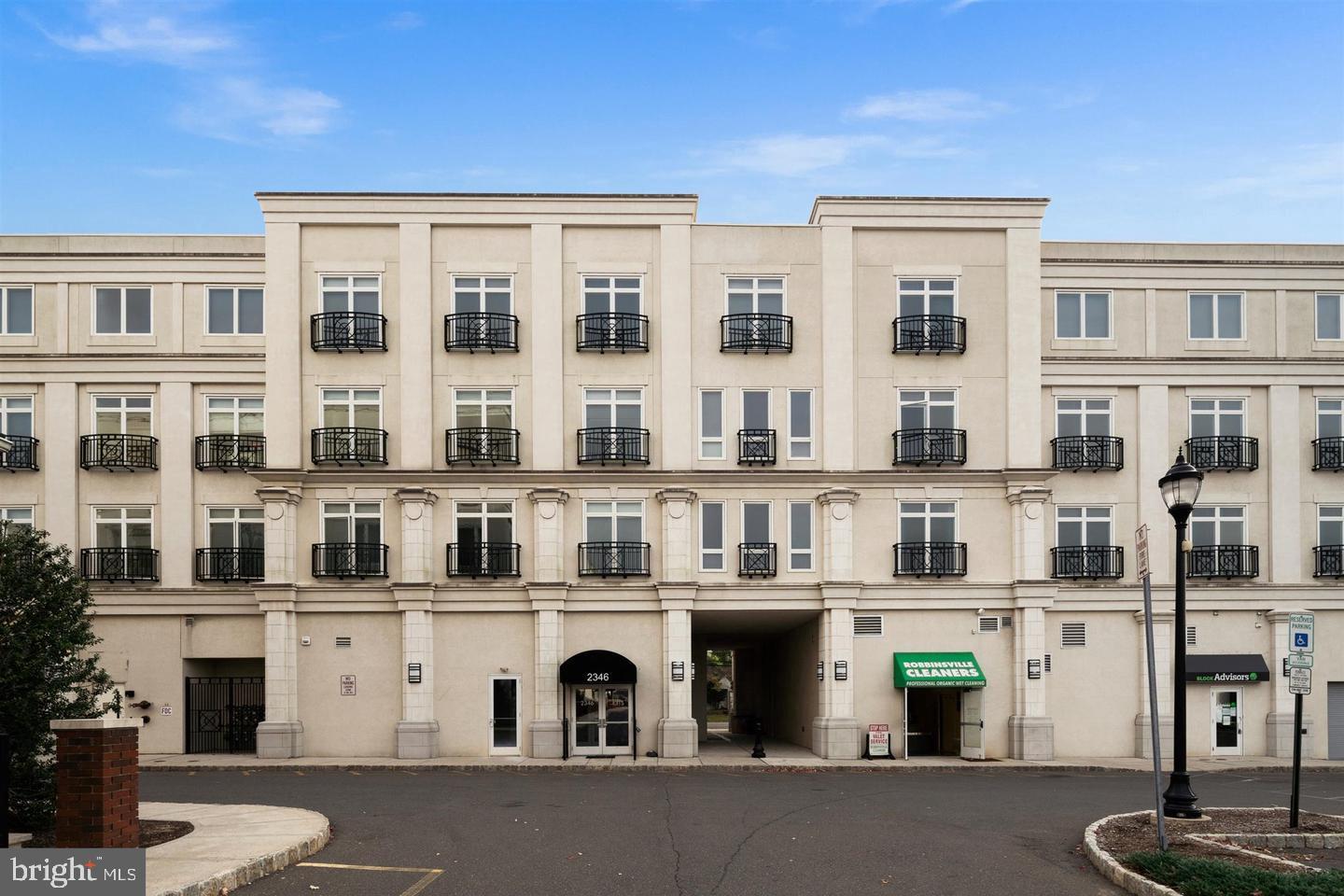 2346 Highway 33, Unit 302 Robbinsville, NJ 08691 - Photo 1 of 21 a front view of a building with glass windows and plants
