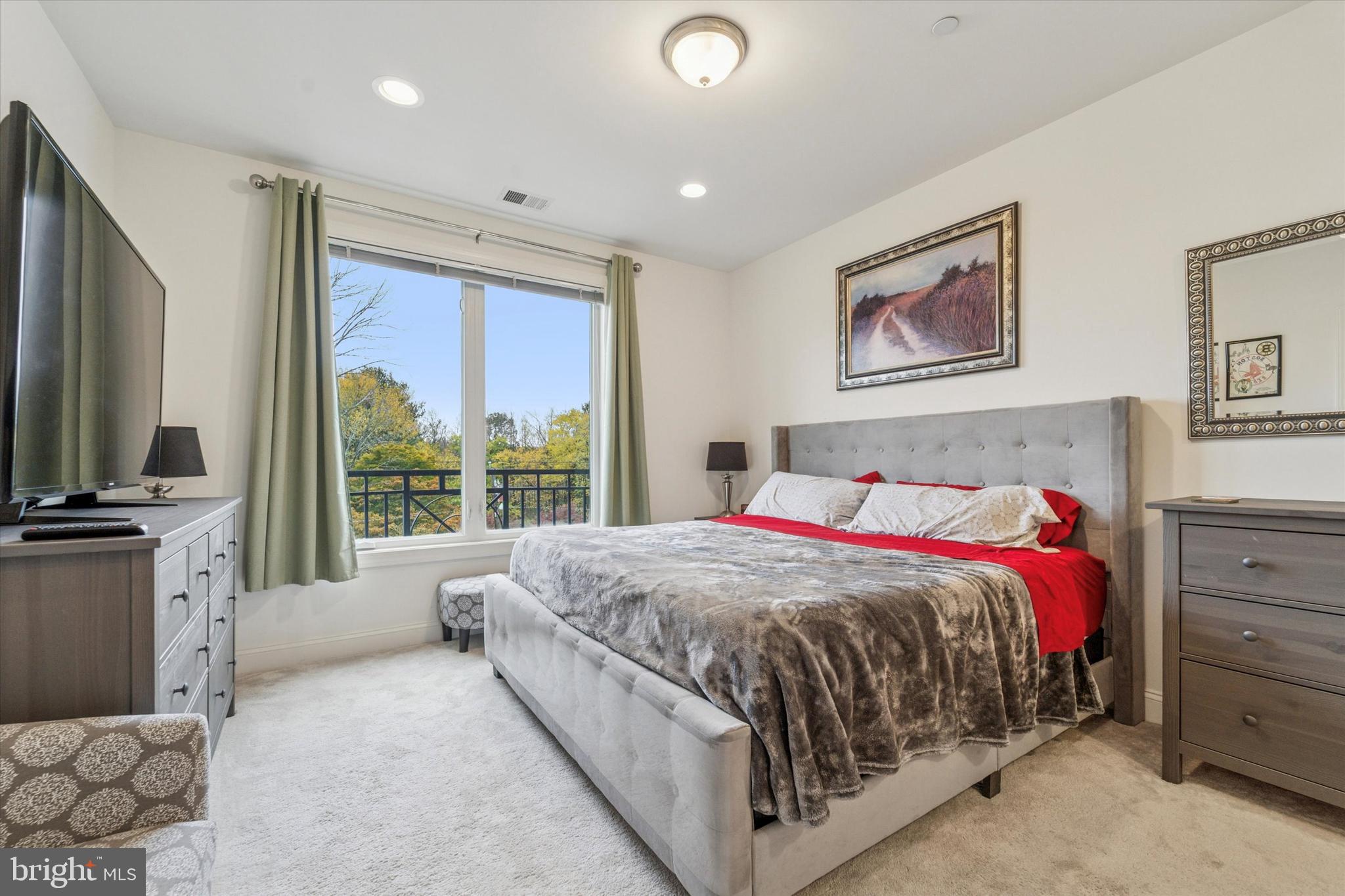 2346 Highway 33, Unit 302 Robbinsville, NJ 08691 - Photo 11 of 21 a bedroom with a large bed and a flat tv screen