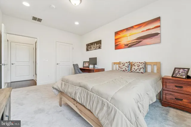 a bedroom with a bed and a painting on the wall