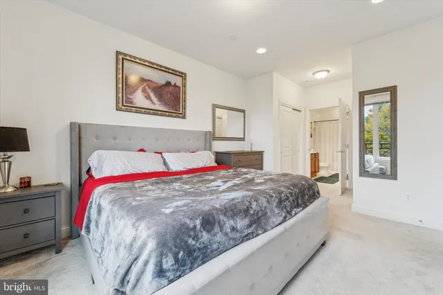 a bed sitting in a bedroom and night stand