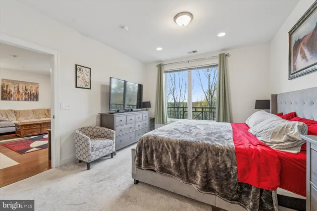 a bedroom with a bed flat screen tv and window