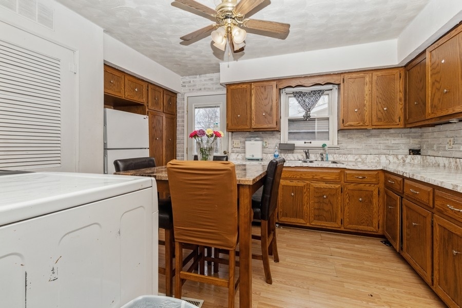 2305 Marmion Avenue Joliet, IL 60436 - Photo 5 of 10 a kitchen that has a cabinets counter space dining table and a sink