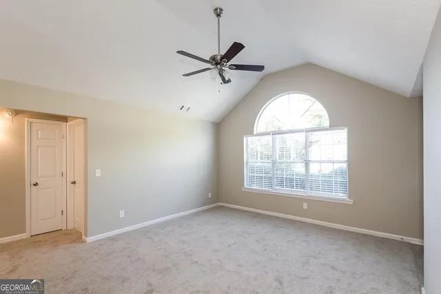 an empty room with a window and a fan