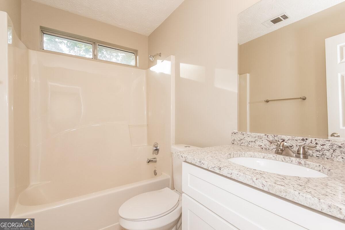 1136 Oakwood Manor Court Decatur, GA 30032 - Photo 8 of 15 a bathroom with a granite countertop sink toilet and shower