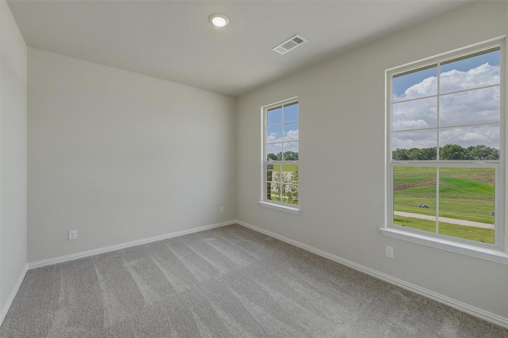 1209 Colca Drive Springtown, TX 76082 - Photo 10 of 24 Bright room featuring two large windows, neutral gray carpet, white baseboards, and a recessed ceiling light