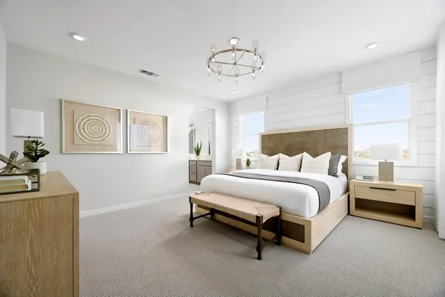 a spacious bedroom with a bed and a chandelier