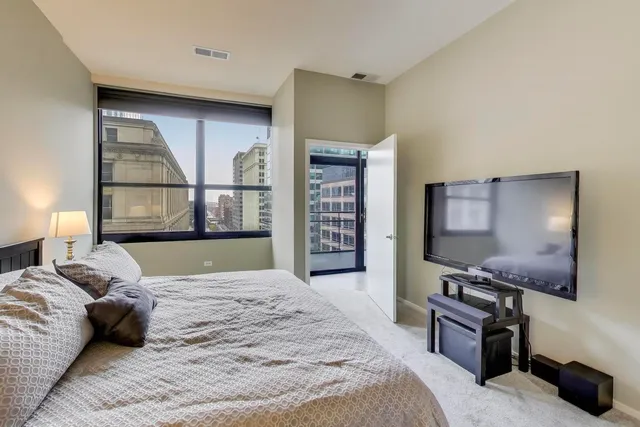 a bedroom with a bed and a flat screen tv