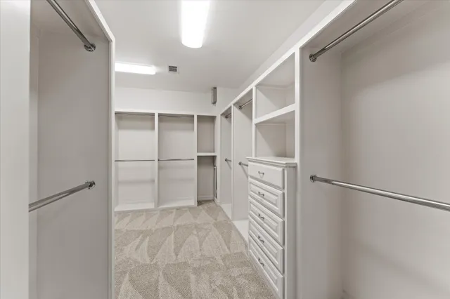 a view of walk in closet with empty racks
