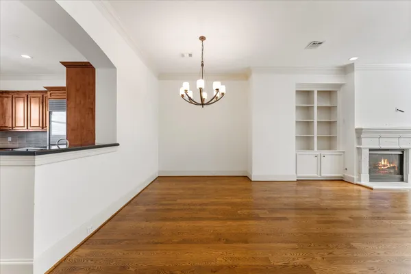 a view of empty room with wooden floor and fireplace