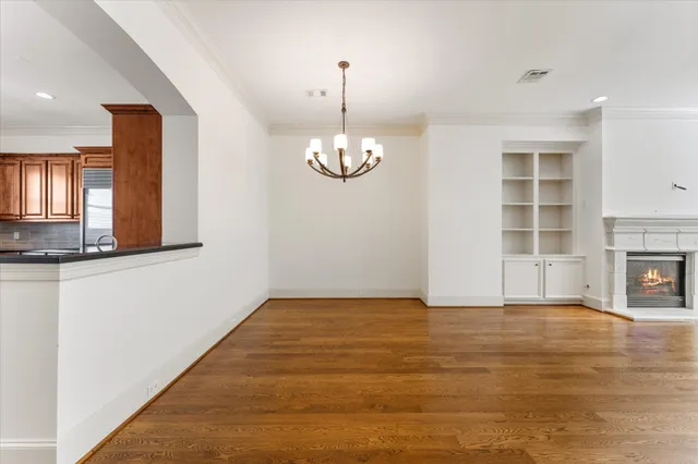 a view of empty room with wooden floor and fireplace