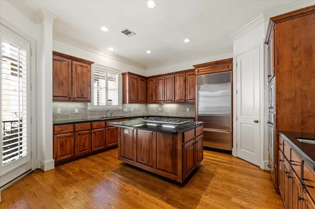 a kitchen with stainless steel appliances granite countertop a stove a sink and a refrigerator