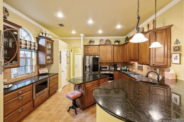 a kitchen with stainless steel appliances granite countertop a refrigerator and a stove