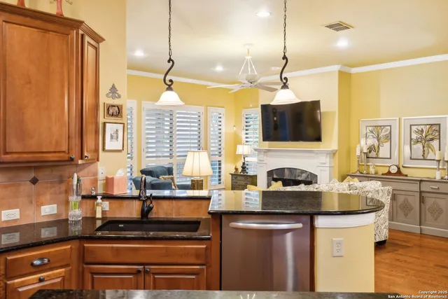 a kitchen with stainless steel appliances granite countertop a stove and a view of living room