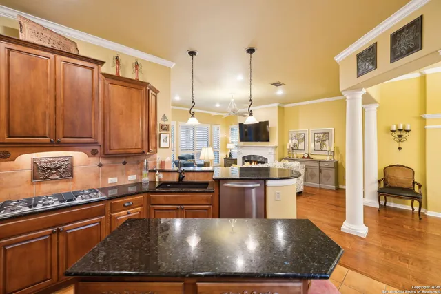 a kitchen with stainless steel appliances granite countertop a refrigerator a sink dishwasher a stove with wooden cabinets and floor