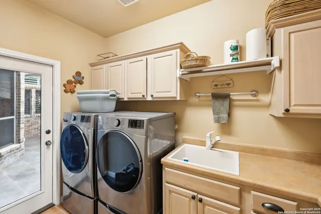 a backyard of a house with plants and large tree
