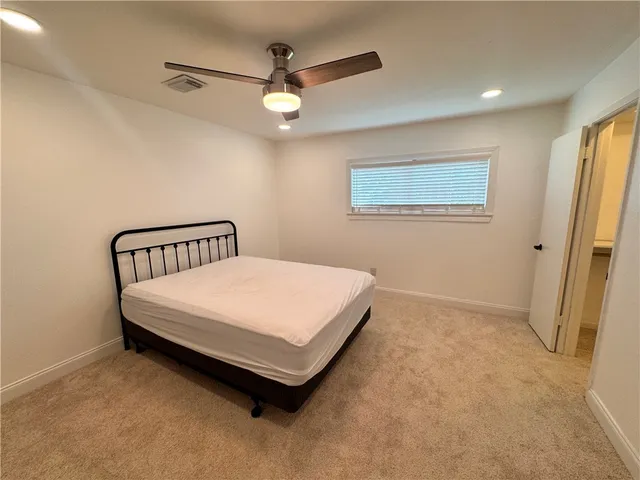 a bedroom with a bed and a ceiling fan