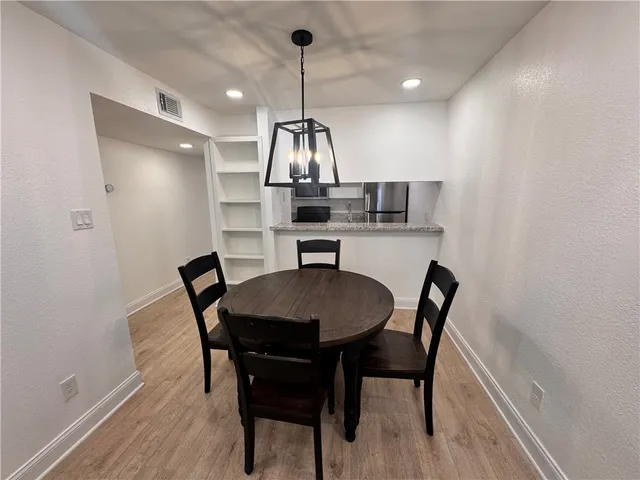 a view of a dining room with a table and chairs
