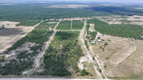 an aerial view of a house with a yard and lake view