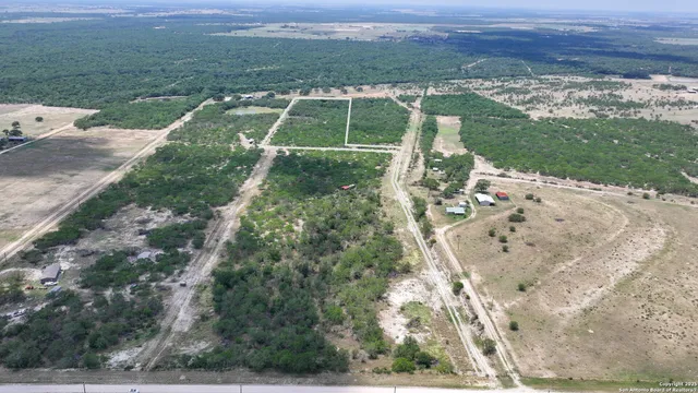 an aerial view of a house with a yard and lake view
